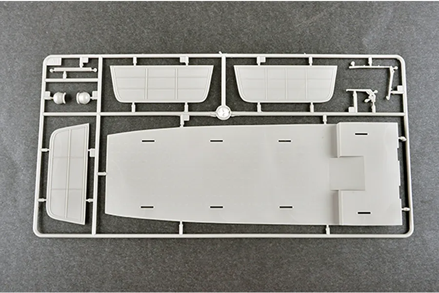 A grey plastic model kit sprue containing a large flat deck piece and smaller panel components for a 1/350 scale ship model.