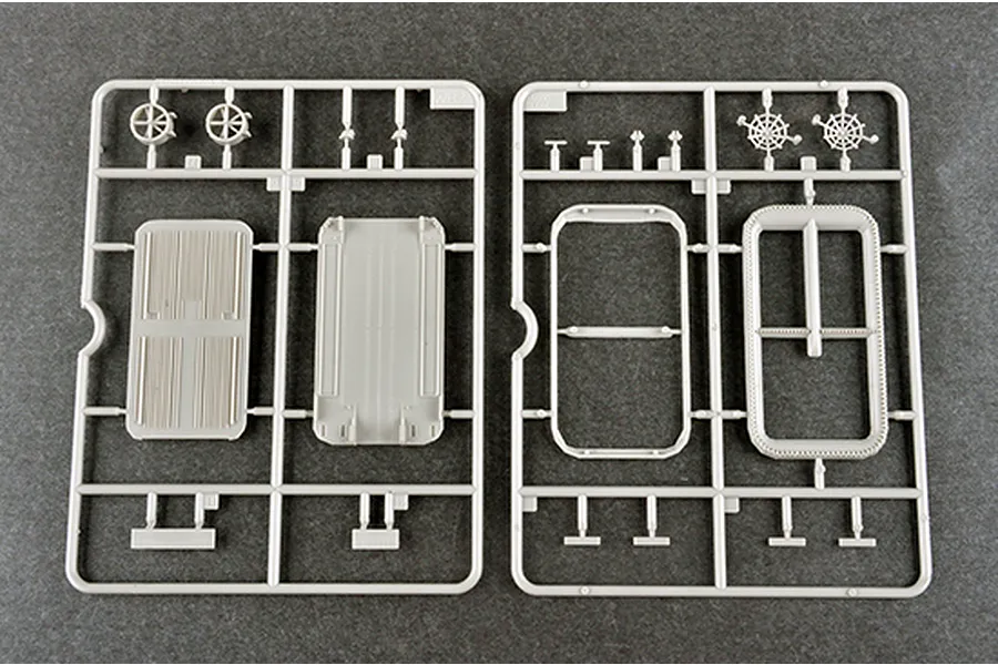 Two grey plastic model kit sprues containing various ship deck and structural components on a dark grey background.