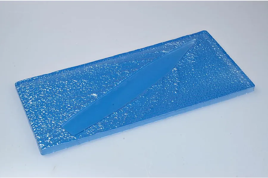 A blue plastic display base representing water for a 1/700 scale model ship kit.
