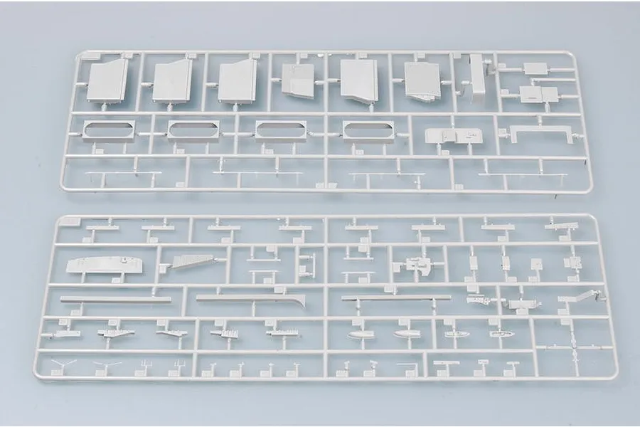Two grey plastic model kit sprues containing various ship parts laid out on a light grey background.