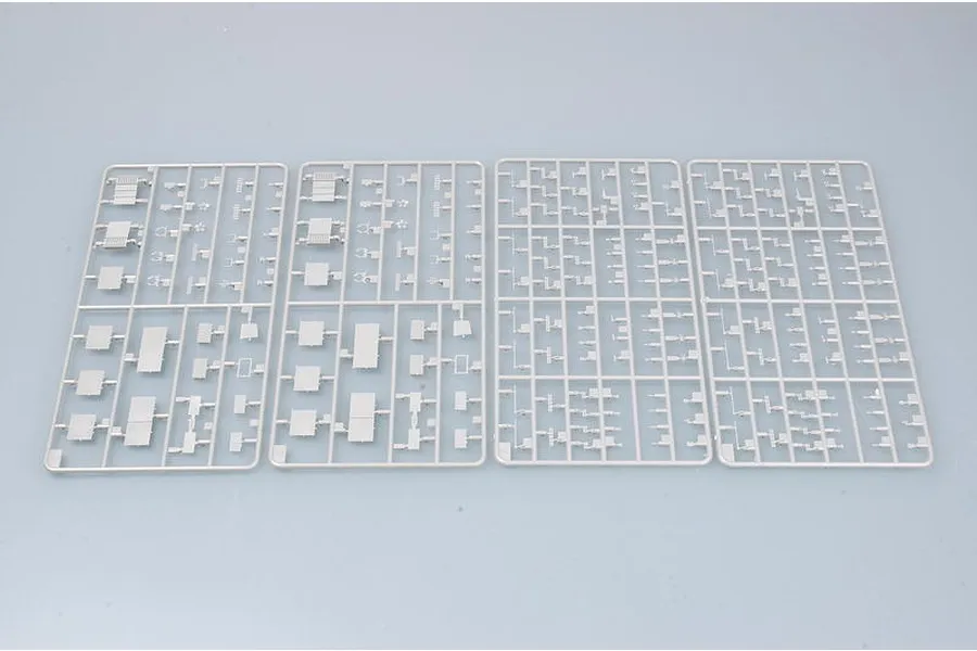 Four grey plastic model kit sprues containing various small aircraft parts for a 1/700 scale model ship.