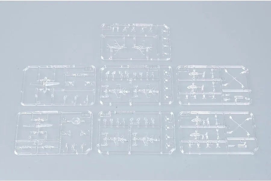 Seven clear plastic model kit sprues containing miniature aircraft and helicopter parts for a 1/700 scale model.