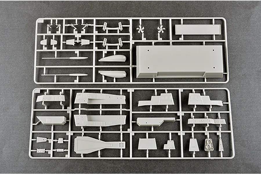 Two grey plastic model kit sprues containing various ship parts laid out on a dark grey surface.