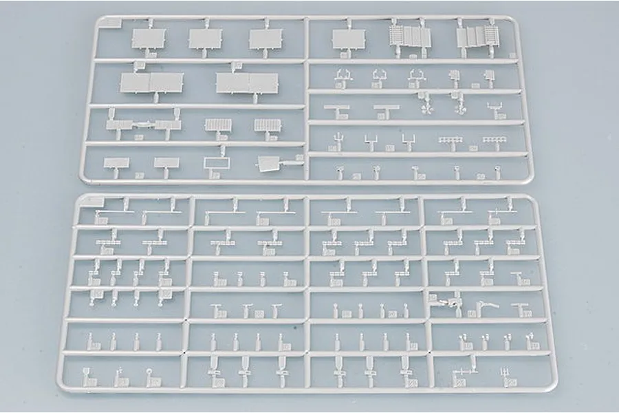 Two grey plastic model kit sprues containing various small aircraft carrier parts, viewed from above on a neutral background.