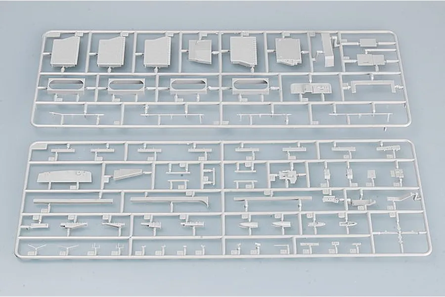 Two grey plastic model kit sprues containing various small parts for a ship model, laid out on a plain light grey background.
