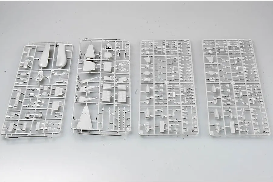 Four grey plastic model kit sprues containing various ship parts laid out on a plain white background.