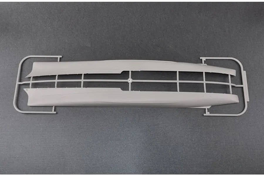 A grey plastic sprue containing the two hull halves for a 1/350 scale model ship kit, viewed from above against a dark grey background.