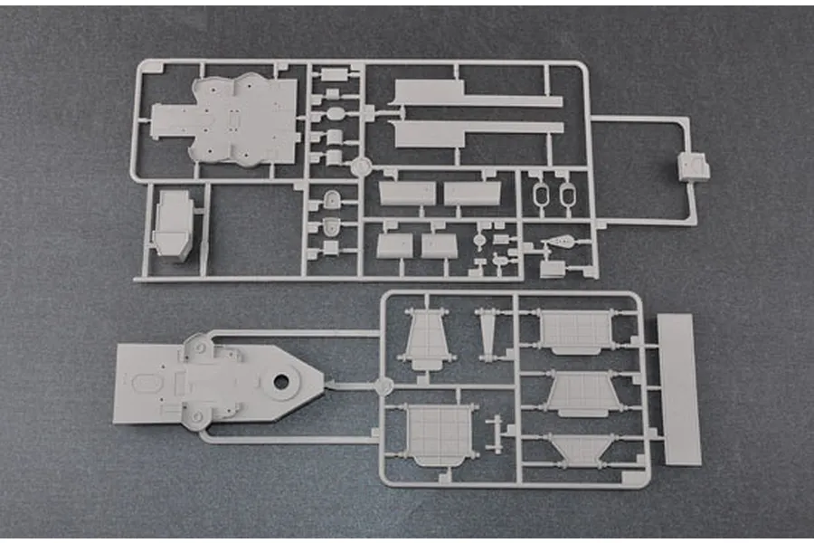 Two grey plastic model kit sprues containing various ship parts laid out on a dark grey surface.