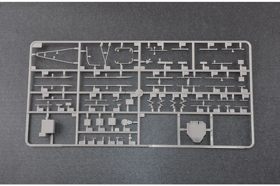 A grey plastic model kit sprue containing various small parts for a ship model, viewed from above against a dark grey background.