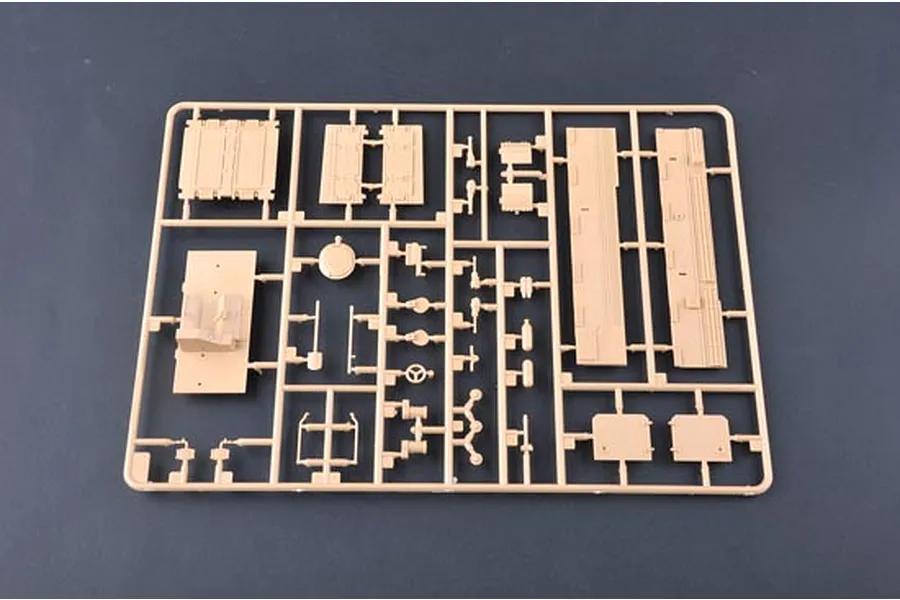 A tan plastic sprue containing various unpainted model tank parts for a 1/35 scale kit, set against a dark grey background.