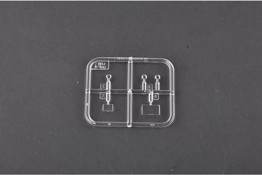 A small clear plastic sprue containing four small model parts on a dark grey background.