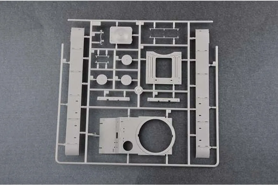 A grey plastic sprue containing various model tank parts, including hull sections and turret components, for a 1/35 scale model kit.