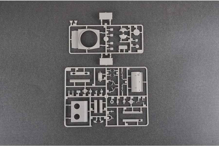 Two grey plastic model kit sprues containing various tank parts, laid out on a dark grey surface.