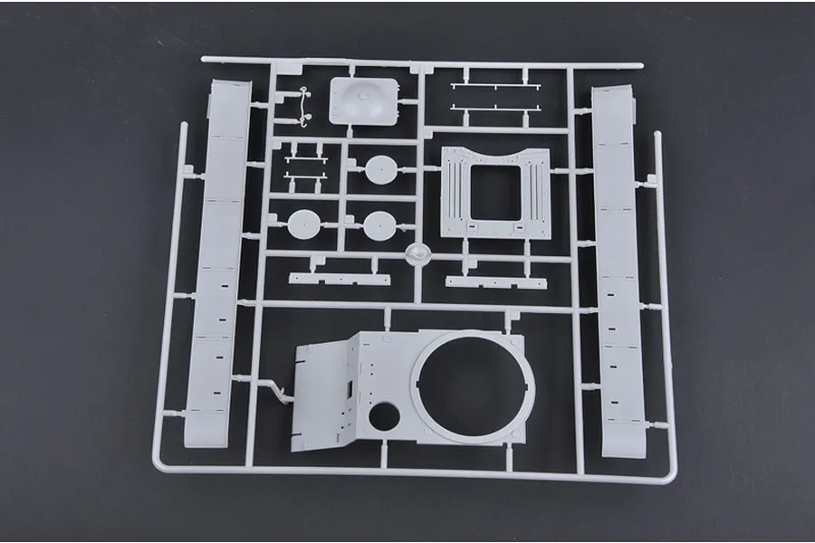A grey plastic sprue from a 1/35 scale model kit featuring tank hull and turret components on a dark background.