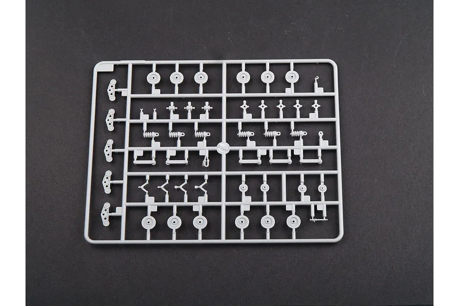 A grey plastic model kit sprue containing various small suspension and wheel components for a 1/35 scale tank model.