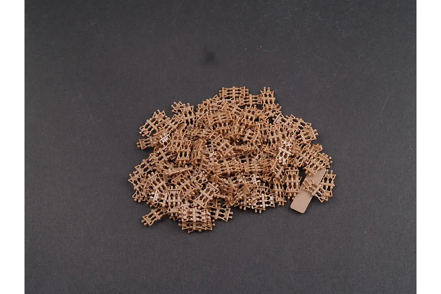 A pile of individual brown plastic tank track links for a 1/35 scale model kit.