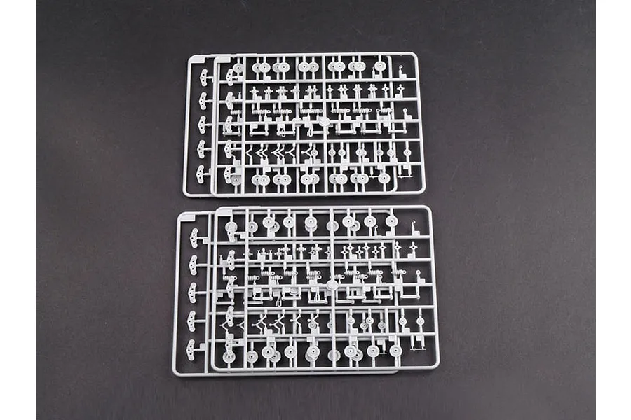 Two identical grey plastic model kit sprues containing small suspension and wheel components for a 1/35 scale tank model.
