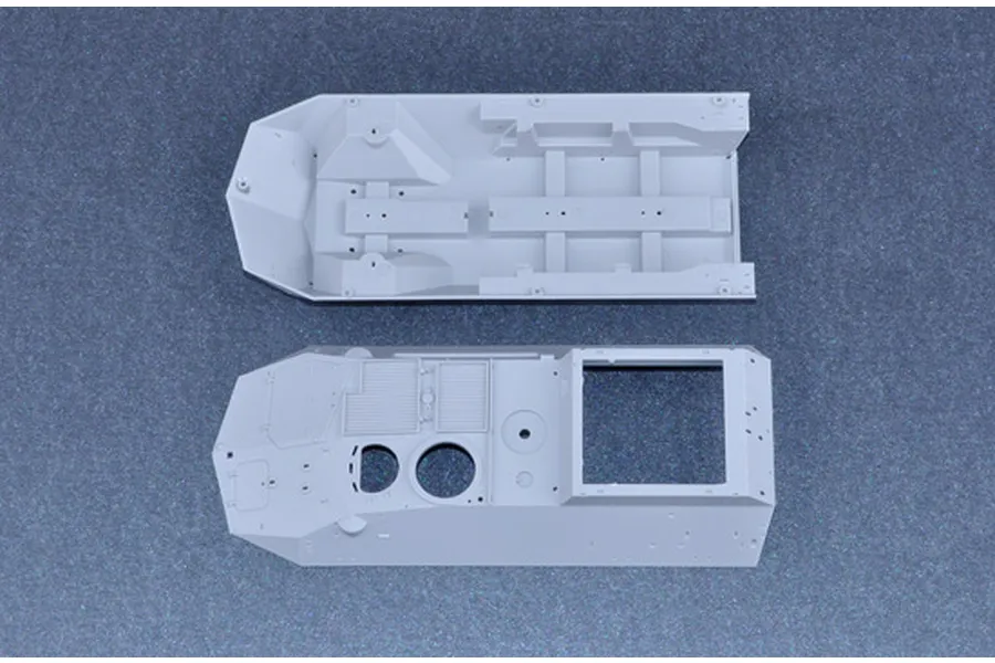Top-down view of two unpainted grey plastic model kit parts for a 1/35 scale armoured vehicle, showing the hull interior and upper deck.
