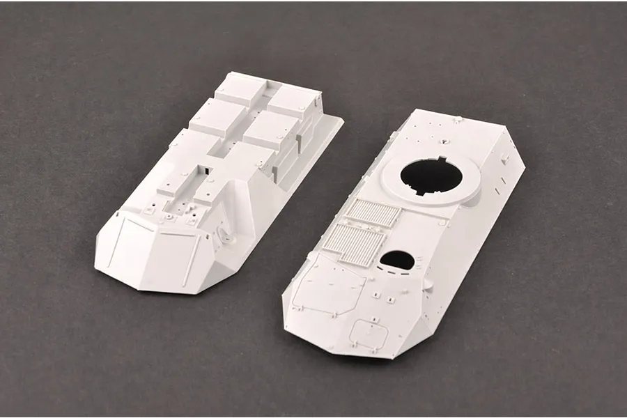 Two unpainted grey plastic model kit parts for a 1/35 scale armoured vehicle, showing the upper and lower hull sections.