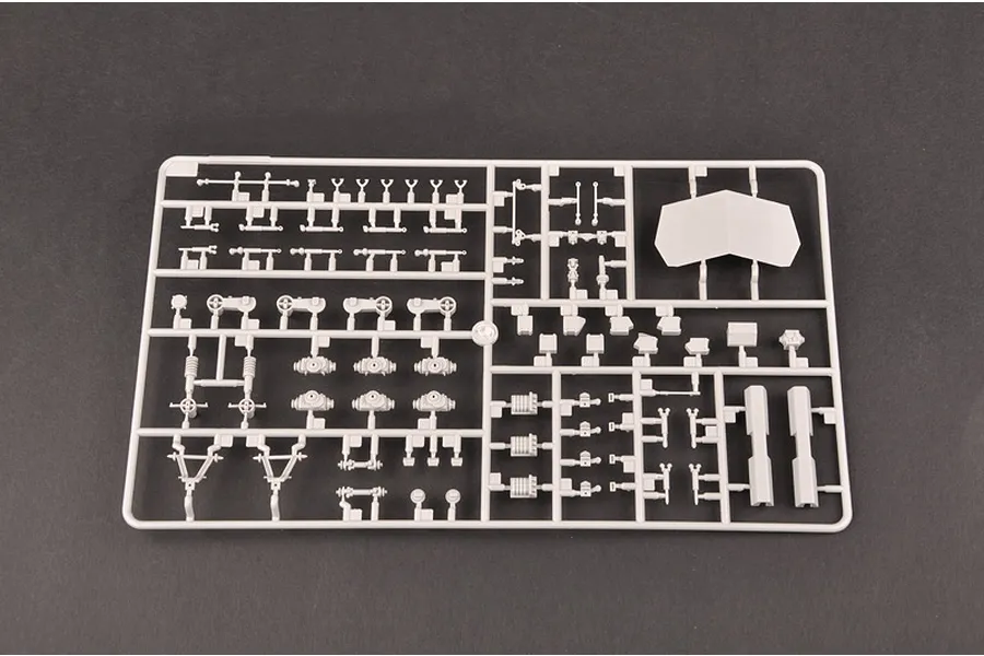 A grey plastic sprue containing various small model parts for a 1/35 scale armoured vehicle kit, set against a dark grey background.