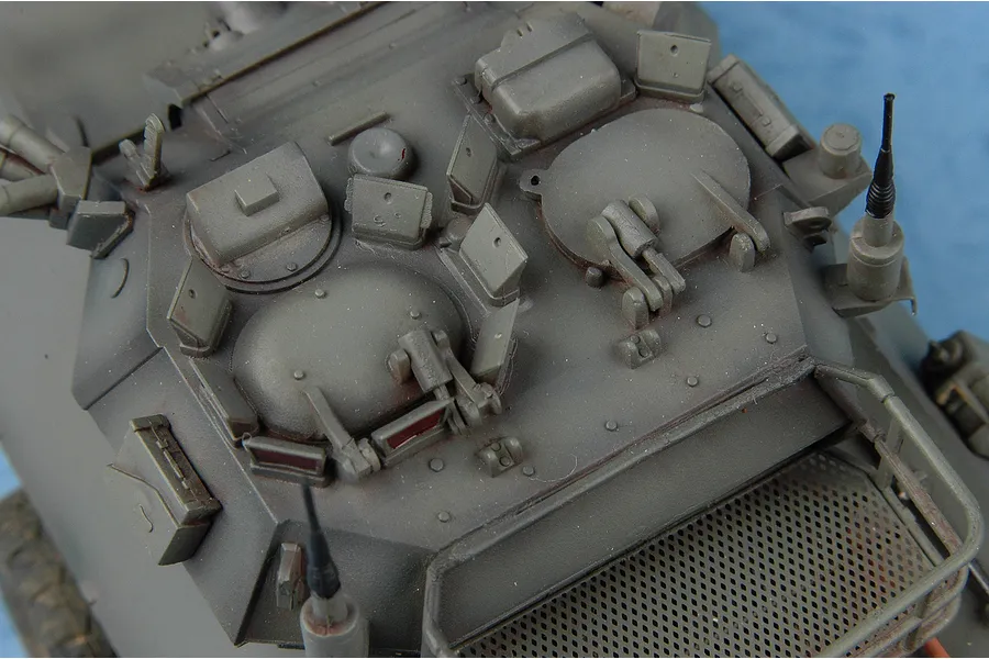 Top-down view of a 1/35 scale plastic model of a Canadian Cougar AVGP armoured vehicle, showing turret hatches, antennas, and detailed surface features.