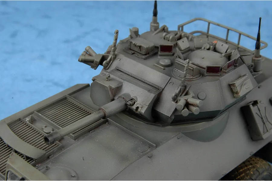 A high-angle close-up of a 1/35 scale model of a Canadian Cougar AVGP armoured vehicle, showing the turret, main gun, and hatches.
