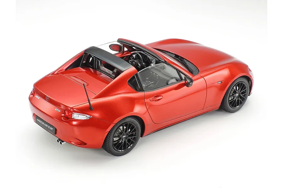 A high-angle studio shot of a 1/24 scale Tamiya Mazda MX-5 RF model car in metallic red with black wheels.