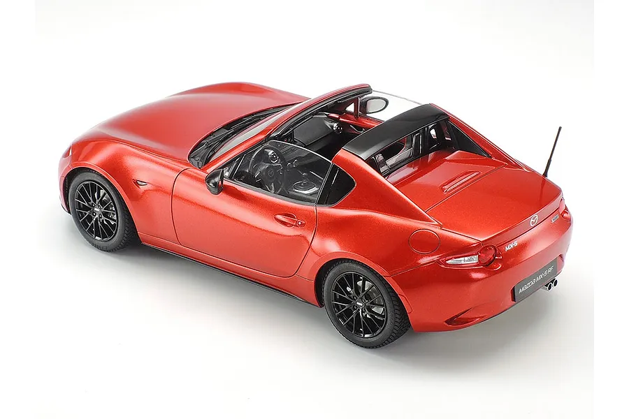 A high-angle rear three-quarter view of a red Tamiya 1/24 scale Mazda MX-5 RF plastic model car on a white background.