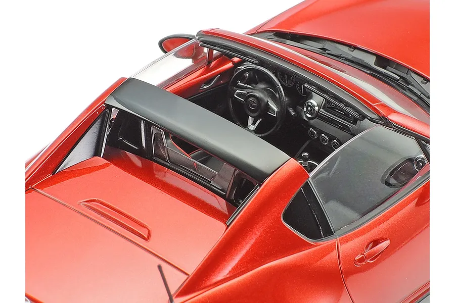 High-angle close-up of a red Tamiya 1/24 Mazda Roadster RF scale model car showing the interior and roof structure.