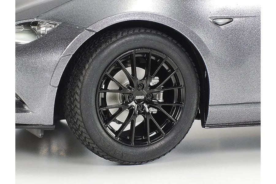 Close-up of the front wheel and fender of a metallic grey Tamiya 1/24 Mazda Roadster RF model car, featuring a black BBS alloy wheel.