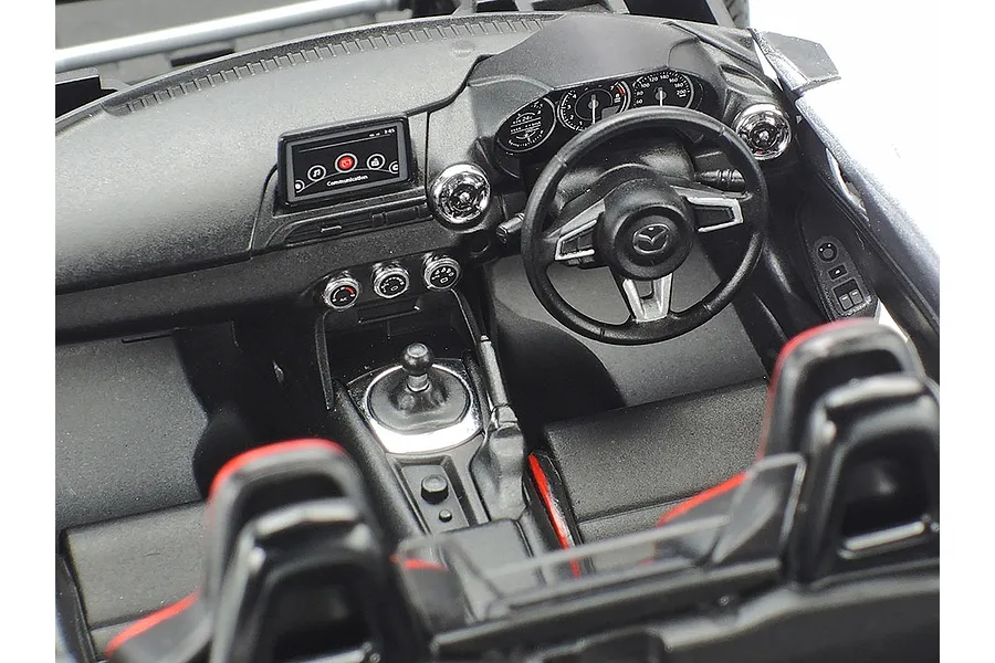 Detailed interior view of a 1/24 scale Tamiya Mazda Roadster RF model kit showing the dashboard, steering wheel, and seats.