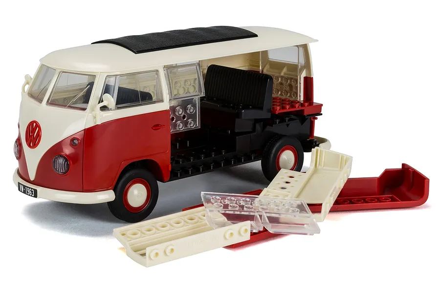 Airfix Quickbuild Volkswagen Kombi Camper Van model kit partially assembled with loose plastic parts on a white background.