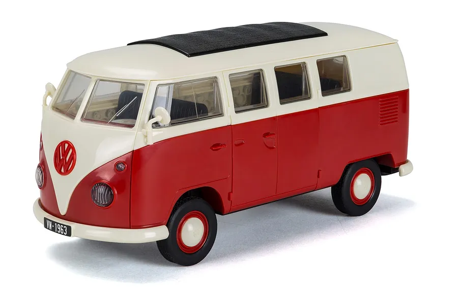 A studio shot of an assembled Airfix Quickbuild Volkswagen Kombi Camper Van model in red and white, viewed from the front three-quarter angle.