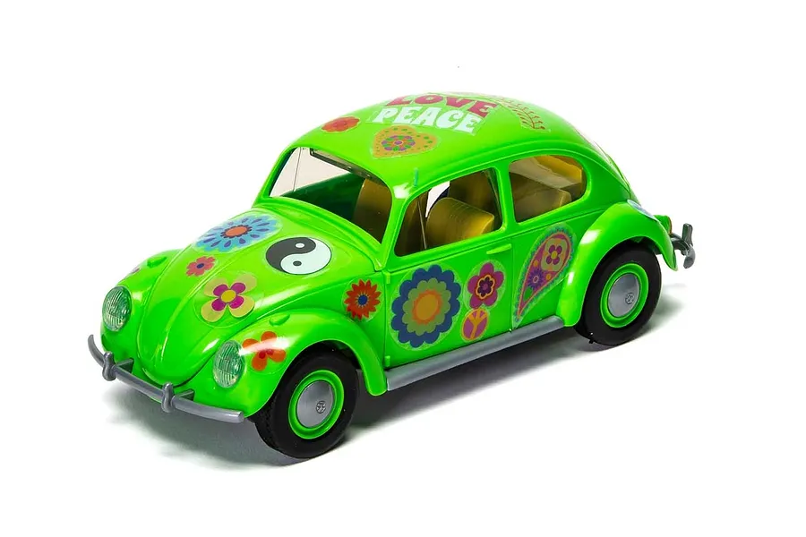 A bright green Airfix Quickbuild Volkswagen Beetle model car featuring colorful flower power decals, a yin-yang symbol, and the word PEACE on the roof.