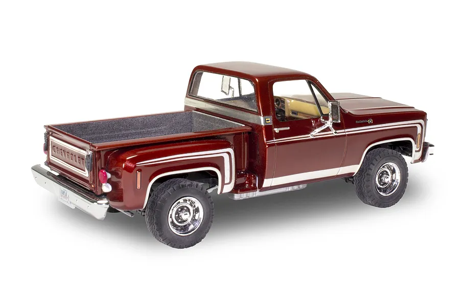 A completed 1/24 scale model of a 1976 Chevrolet Stepside pickup truck in deep metallic red with white side stripes.