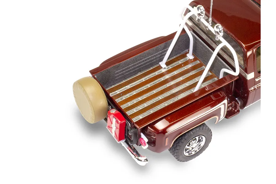 High-angle view of the rear bed of a 1/24 scale 1976 Chevrolet Stepside pickup model, featuring a wood-look bed, roll bar, and spare tire.
