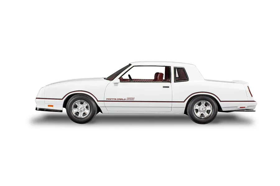 Side profile view of a white 1986 Chevrolet Monte Carlo SS model car with red pinstriping and a maroon interior.
