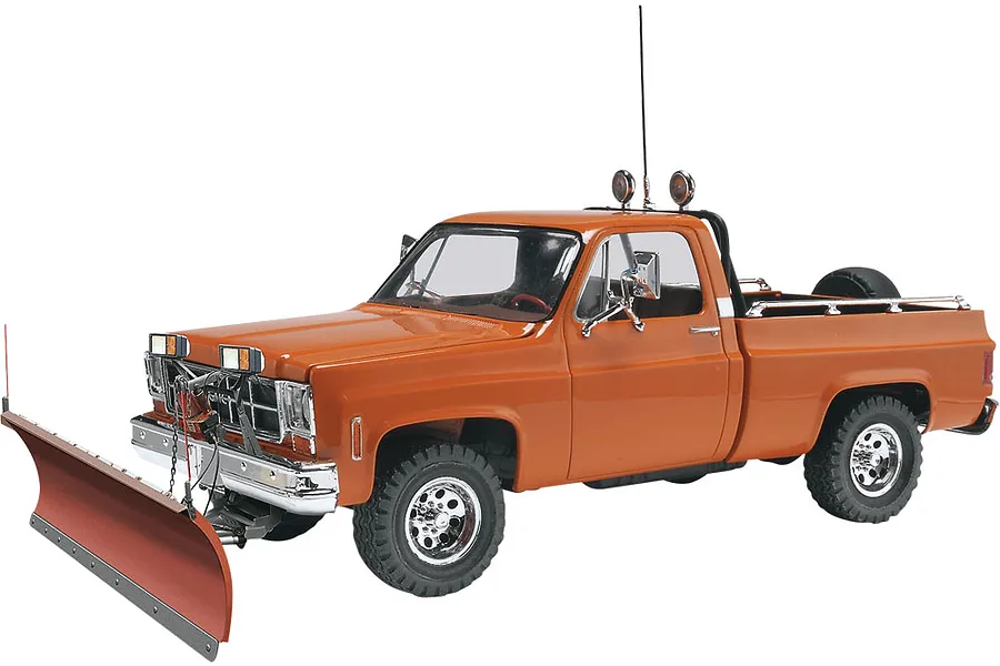 A 1/24 scale model of an orange GMC pickup truck equipped with a front-mounted snow plow, featuring chrome wheels and a roll bar with lights.