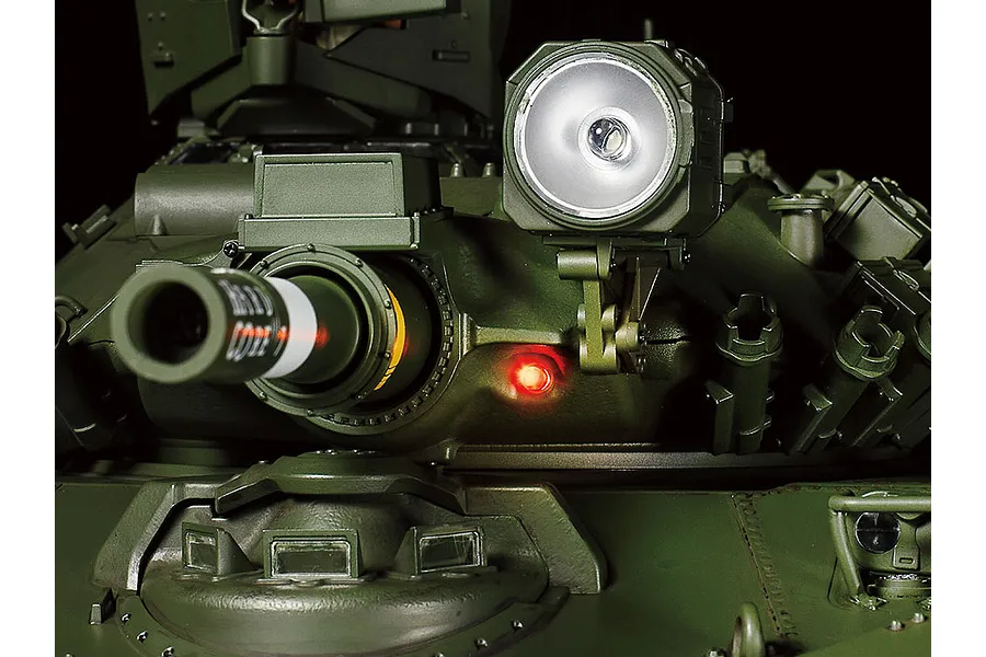 Close-up of the turret of a Tamiya 1/16 scale M551 Sheridan RC tank, showing the main gun, a mounted spotlight, and a glowing red light.