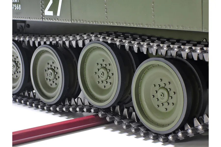 Close-up of the olive green road wheels and black tracks on a 1/16 scale RC tank model.