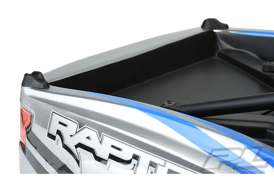 Close-up of a Pro-Line body lid skid plate installed on the rear bed of a silver and blue RC truck body.