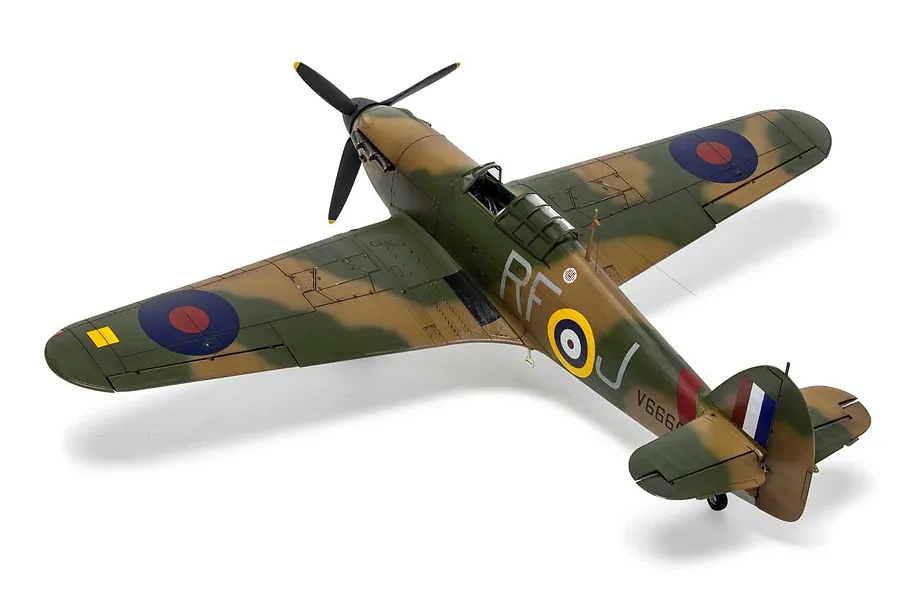 A high-angle studio shot of a completed 1/48 scale Airfix Hawker Hurricane Mk.1 plastic model aircraft with camouflage paint and RAF markings.