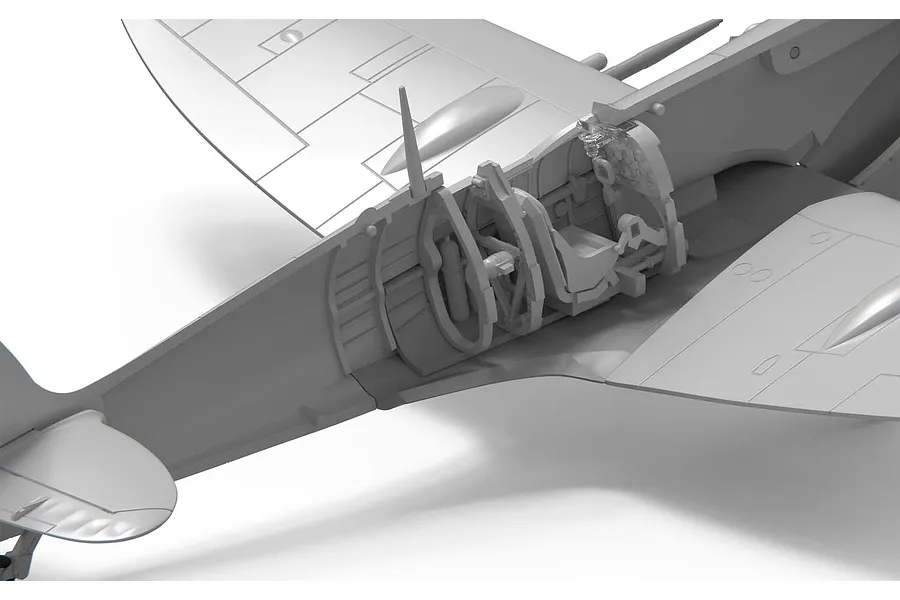 Close-up of the cockpit interior assembly of an unpainted plastic model Spitfire aircraft kit.