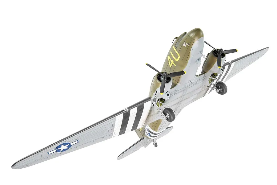 A high-angle studio shot of a fully assembled and painted 1/72 scale Douglas C-47 Skytrain model aircraft, featuring olive drab and silver camouflage.