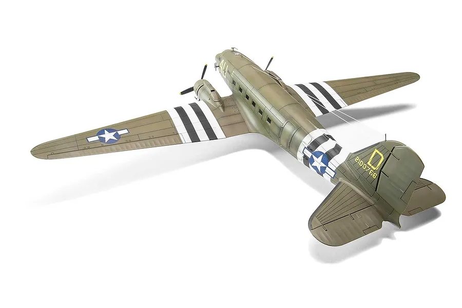 A high-angle view of an assembled and painted 1/72 scale Airfix Douglas C-47 Skytrain model aircraft, featuring olive drab camouflage and invasion stripes.