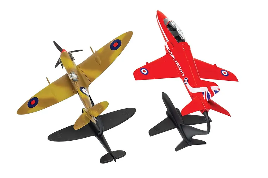 Two assembled and painted Airfix model aircraft, a camouflage Spitfire and a red Royal Air Force Hawk, mounted on black display stands against a white background.