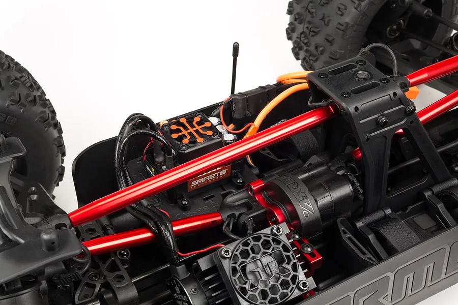 Close-up of the internal chassis of an ARRMA 1/5 scale RC vehicle showing the red aluminium upper chassis brace installed.