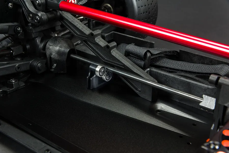 Close-up of an ARRMA RC car chassis showing the center driveshaft support bearing installed on the central driveshaft.