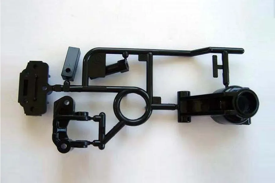 A black plastic Tamiya RC parts tree containing rear hub and hub carrier components.