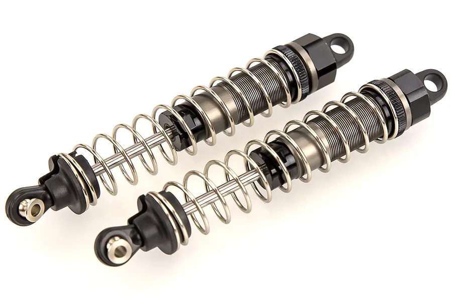 Two assembled RC shock absorbers with black plastic ends and silver metal springs against a white background.